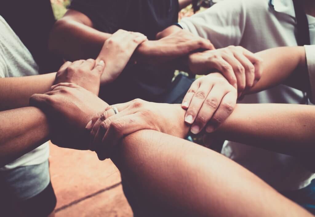 A group of people holding hands connected